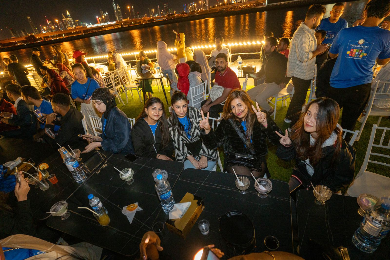 Smiling delegates at a dinner table outdoors at night